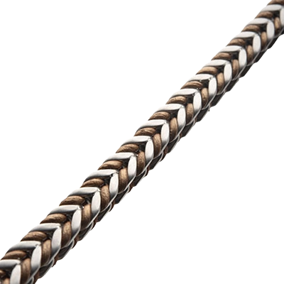 Angled perspective of the INOX men's two-tone woven stainless steel bracelet highlighting its dual-color metallic links and durable finish.