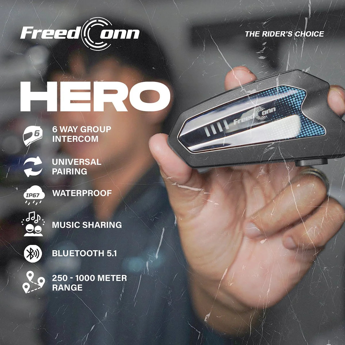 A hand holds a black and silver Freed Conn Hero motorcycle intercom receiver against a blurred background with promotional text listing features like 6-way group intercom, universal pairing, waterproof, and Bluetooth 5.1.